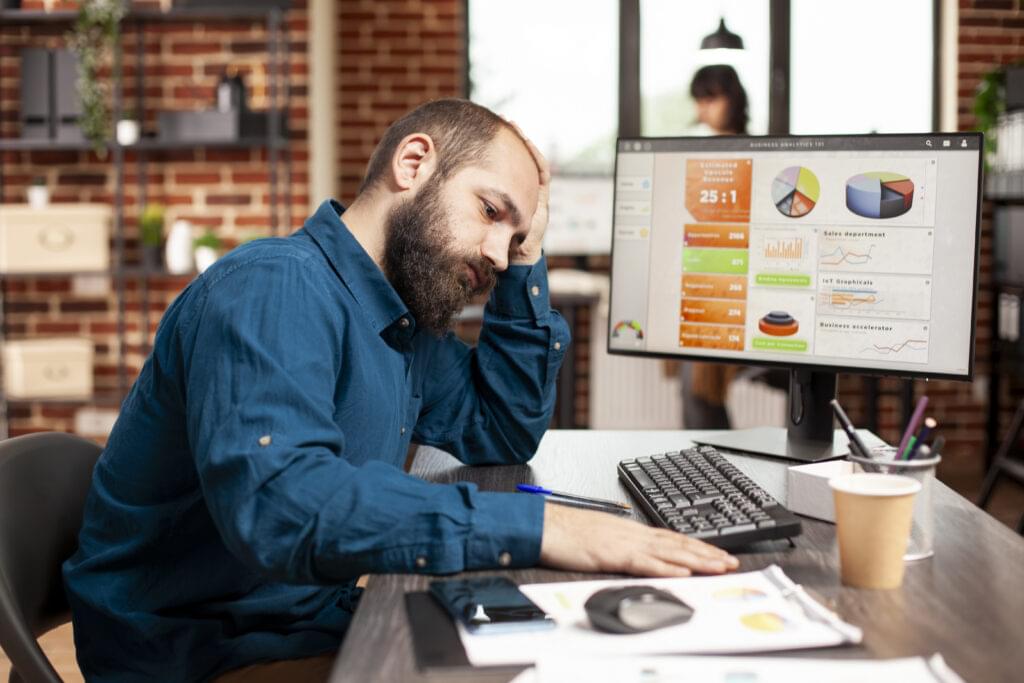 exhausted businessman holds his forehead scaled